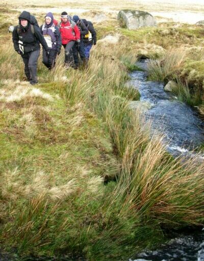 4 hikers walking up hill on Dartmoor